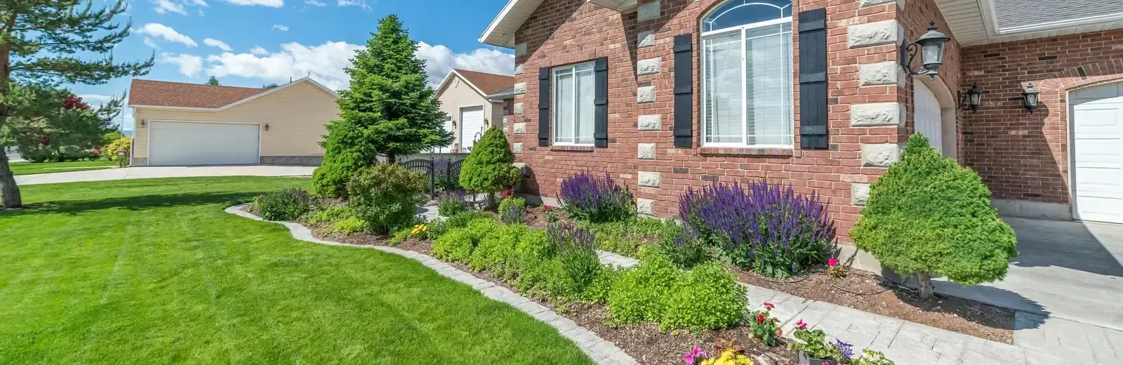 brick house with nice garden bed and shrubs